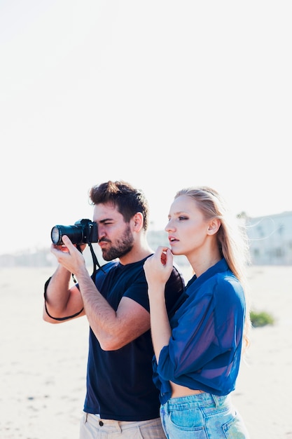 Foto gratuita donna adorabile vicino all'uomo con la macchina fotografica