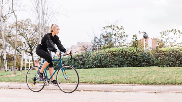 Lovely woman riding bicycle in park