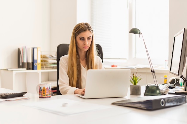 lovely woman using laptop in office