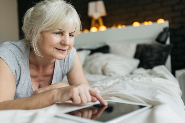 Lovely woman using tablet on bed