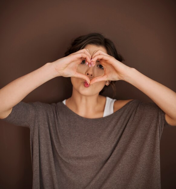 Foto gratuita bella donna con mano segno d'amore