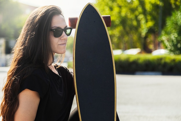 Foto gratuita bella donna con longboard