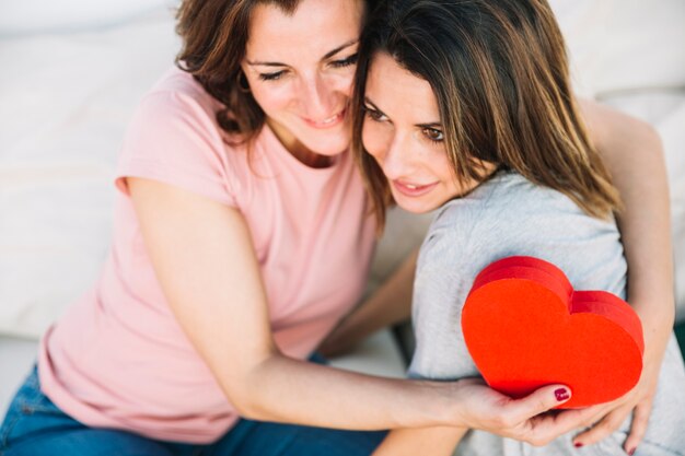 Lovely women with heart-shaped box hugging