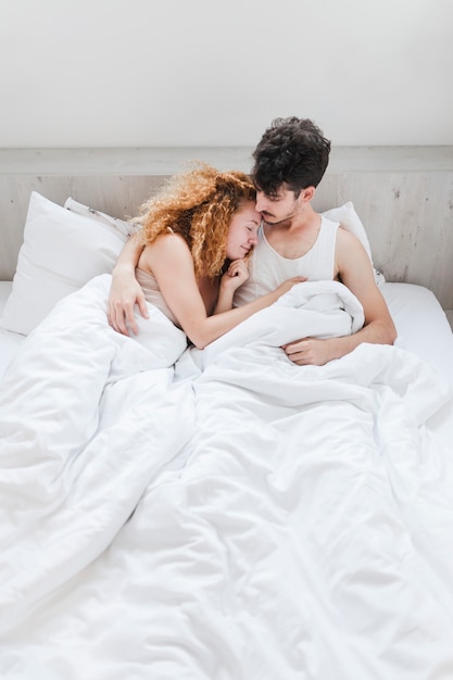 Lovely young couple lying on bed