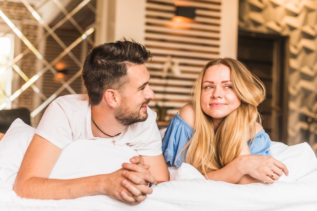 Lovely young couple relaxing on bed