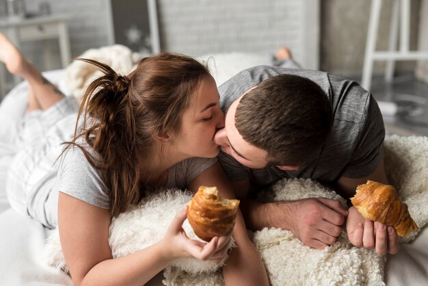 Lovely young man and woman kissing in bed