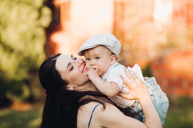 Lovely young mother goes for a walk with her little caucasian baby in the park