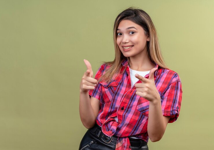 मुफ़्त फोटो a lovely young woman in a checked shirt showing thumbs up
