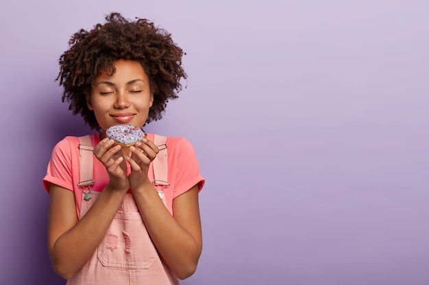 Bella giovane donna con un afro che propone in tuta