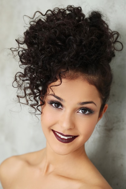 Lovely young woman with black curly hair