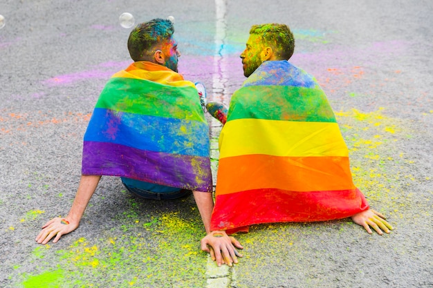 Free photo lovers men sitting on asphalt road