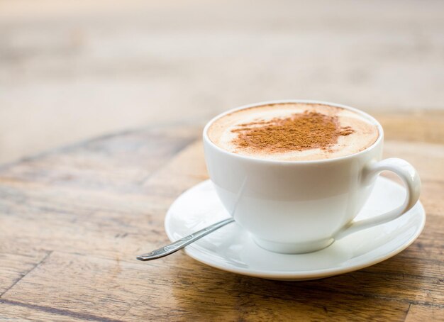 ハートのサインが付いている新鮮なカプチーノの愛情のあるコーヒーカップ