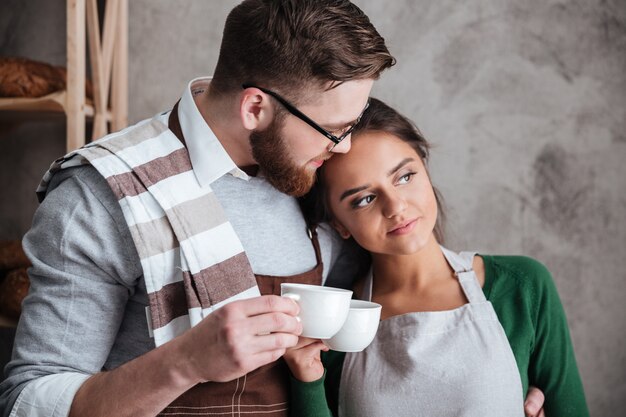 Free photo loving couple bakers drinking coffee