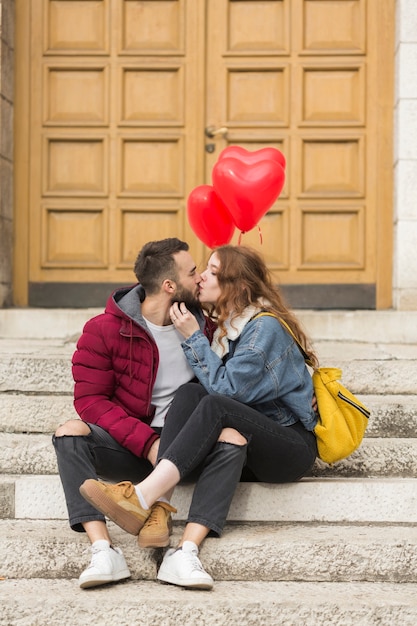 Free photo loving couple kissing outdoors full shot