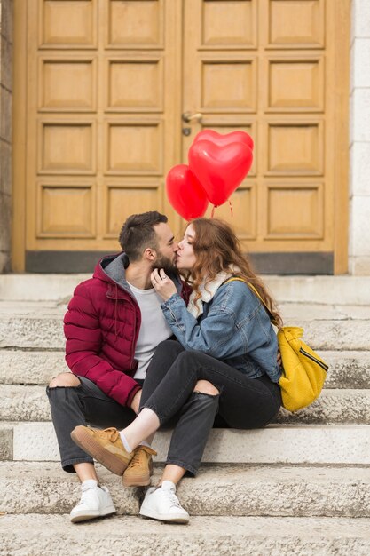 Loving couple kissing outdoors full shot