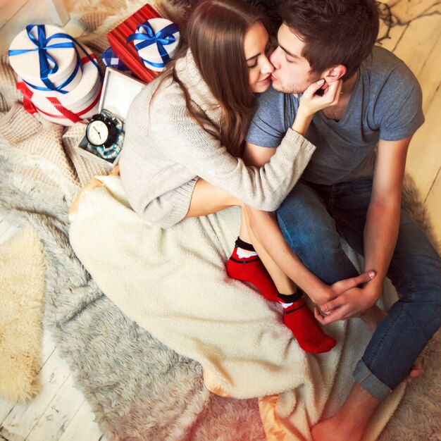 Loving couple kissing with many gifts