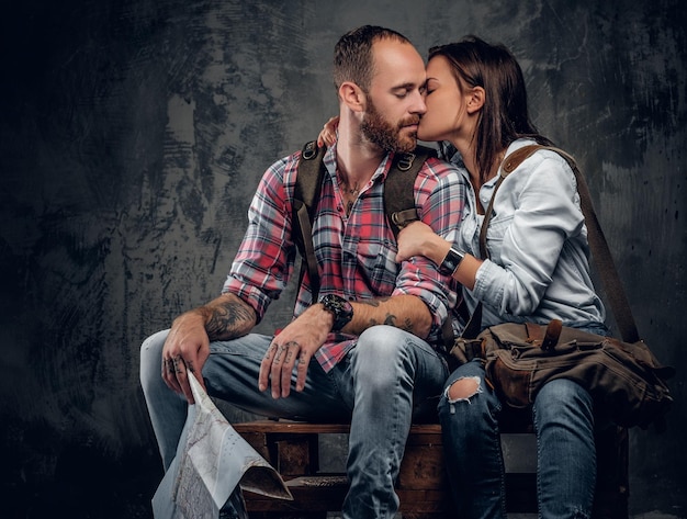 Loving couple ready to travel with backpacks and a map.