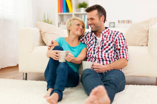 Loving couple relaxing at home with cup of coffee