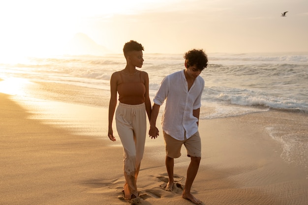 Foto gratuita coppie amorose che mostrano affetto sulla spiaggia vicino all'oceano