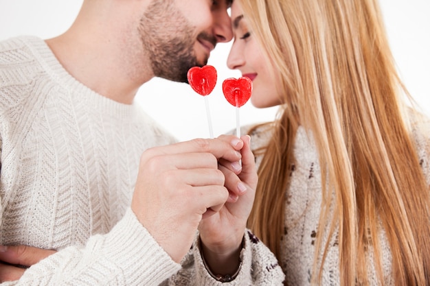 Free photo loving couple showing lollipops