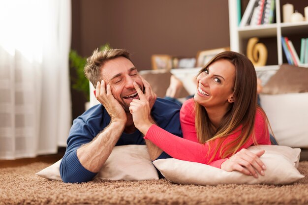 Loving couple spending funny time together on carpet