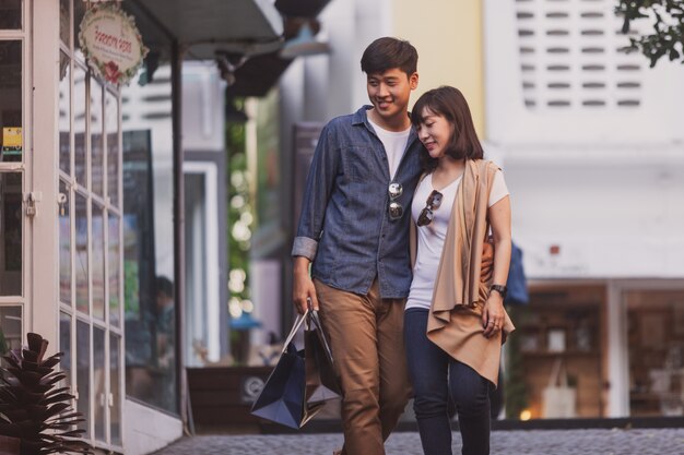 Loving couple strolling with shopping bags