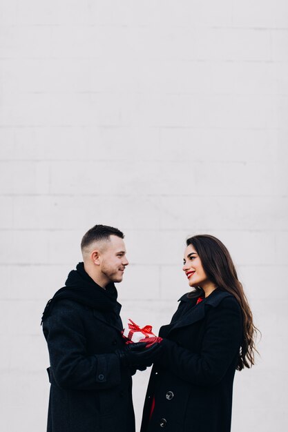 Loving couple with present on white