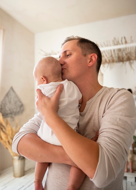 Free photo loving dad with newborn indoors