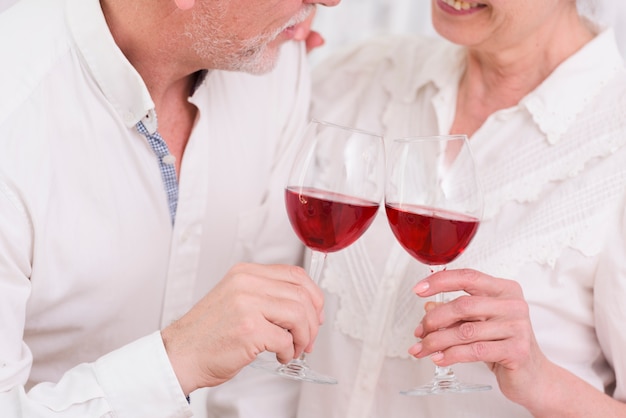 Amare le coppie più anziane che godono del vino rosso a casa