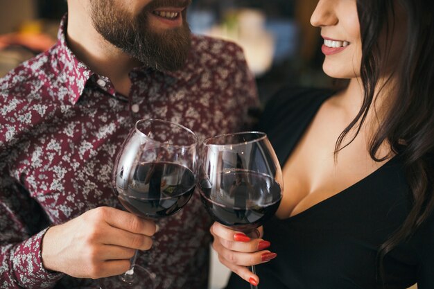 Loving elegant couple clinking with glasses