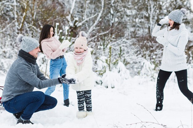 Loving family playing snowballs in countryside