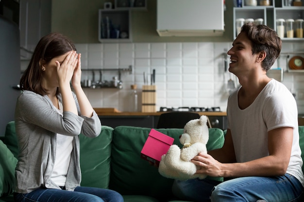 Loving husband closing eyes of wife presenting romantic surprise gift