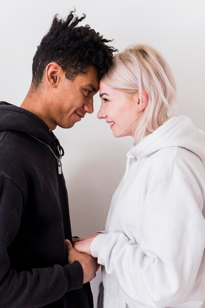 Loving interracial young couple holding each other's hand isolated on white background