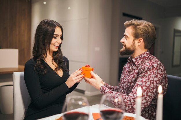 Loving man giving small gift to girl