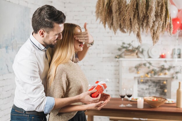 Loving man making surprise for woman