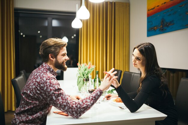 Foto gratuita coppie romantiche amorose che si tengono per mano al tavolo