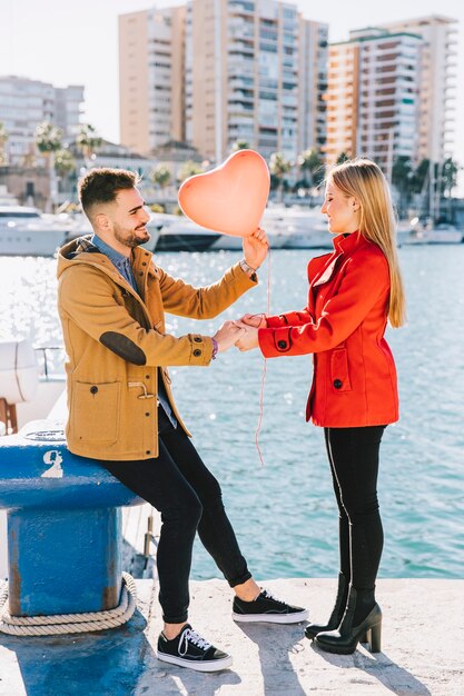 Loving stylish couple posing on bright seafront