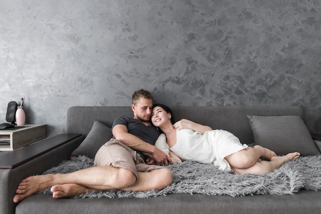 Loving young couple lying on sofa