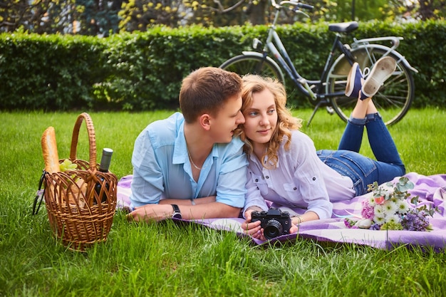사랑스러운 젊은 커플 사진 촬영 및 공원에서 피크닉에서 휴식.