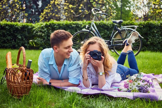 사랑스러운 젊은 커플 사진 촬영 및 공원에서 피크닉에서 휴식.