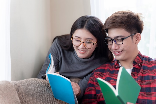 Loving young couple sitting on couch and reading book