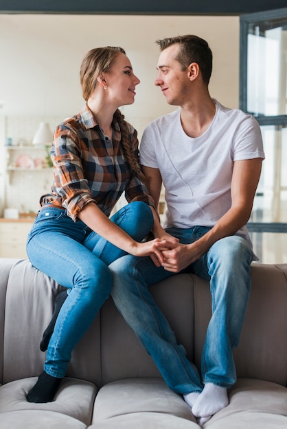 Loving young couple sitting on couch 