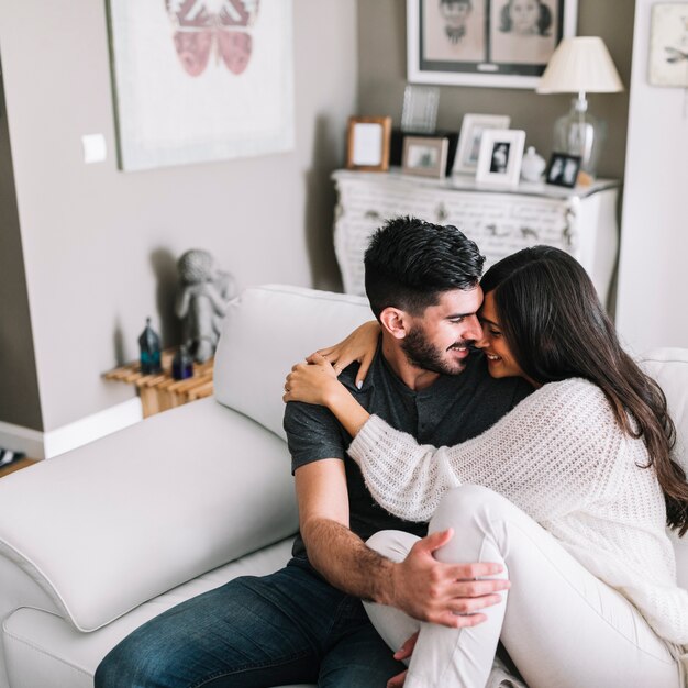 Loving young couple sitting on sofa at home