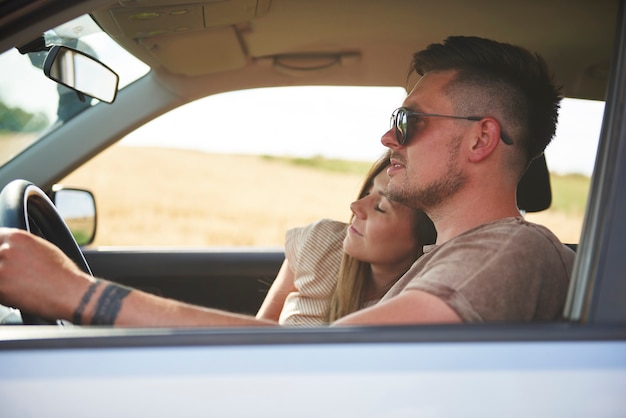 Loving young couple traveling by car