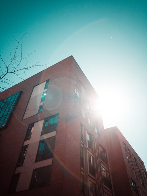 アパートの建物の低角度とその背後にある太陽