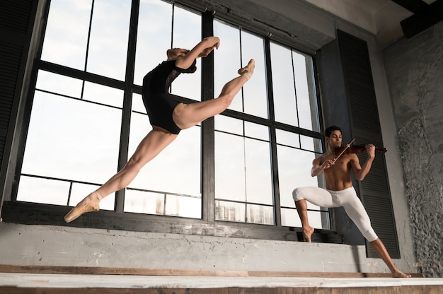 Low angle of ballerina and musician