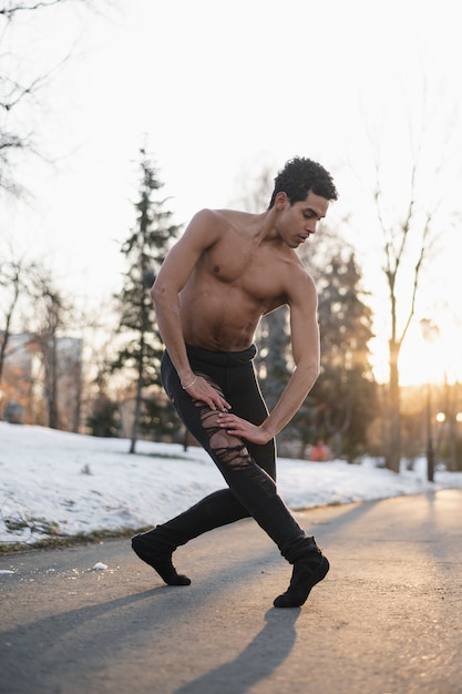 Foto gratuita ballerino di balletto di angolo basso che esegue sulla via