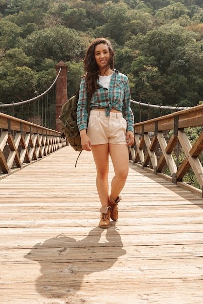 Free photo low angle beautiful woman on bridge