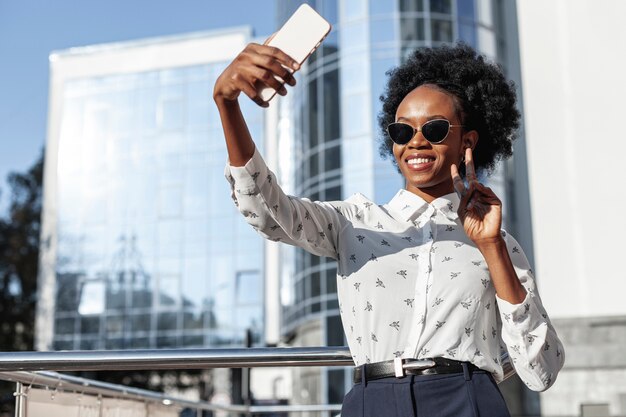 Low angle beautiful woman taking selfies