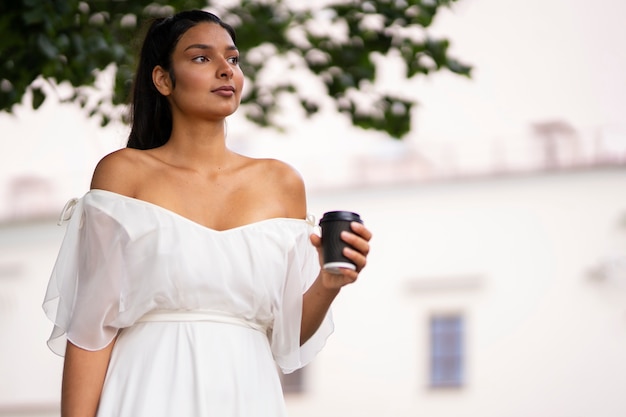 ローアングルのコーヒーカップを持つ美しい女性